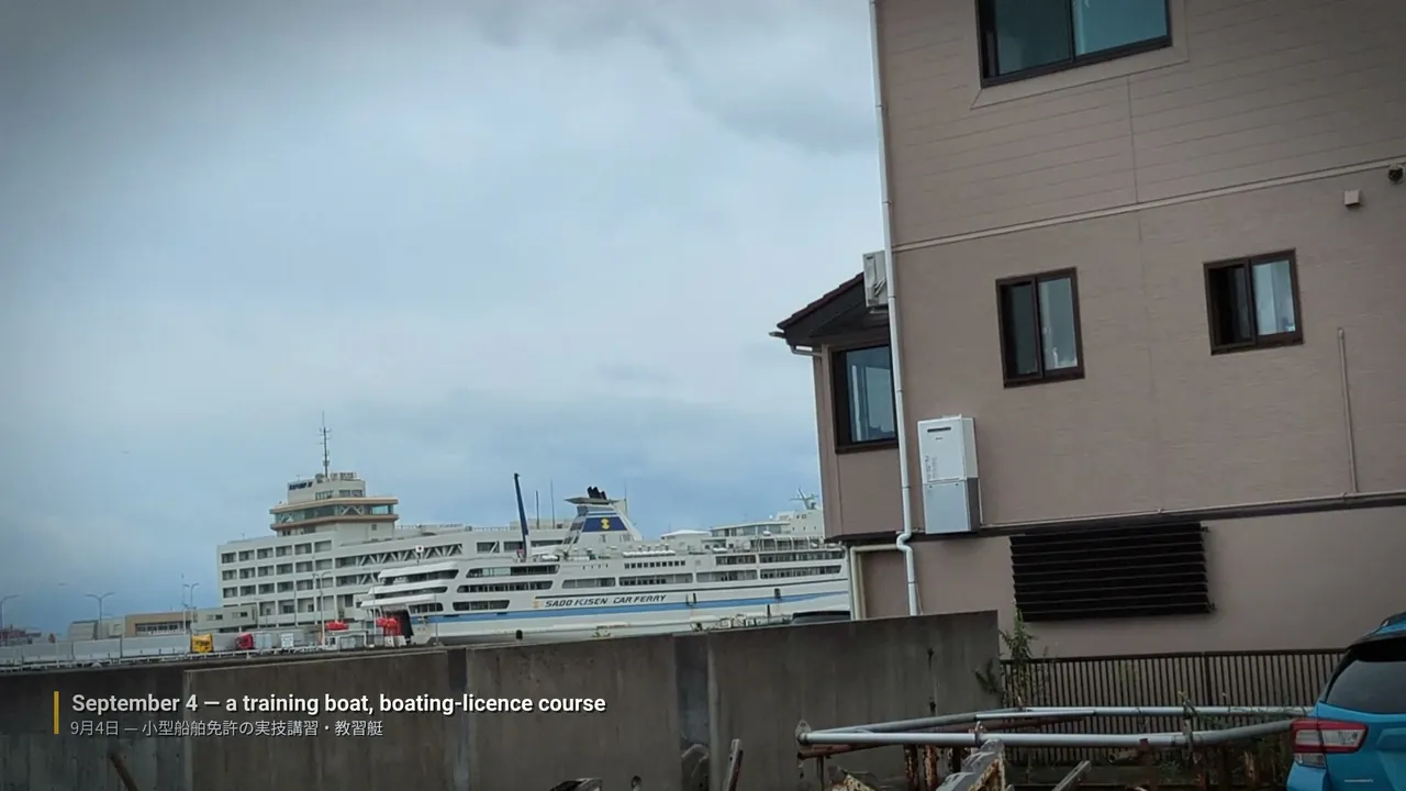 動画の場面。曇り空のマリーナに係留された白い教習艇の実写。左下に「September 4 — a training boat, boating-licence course」の字幕